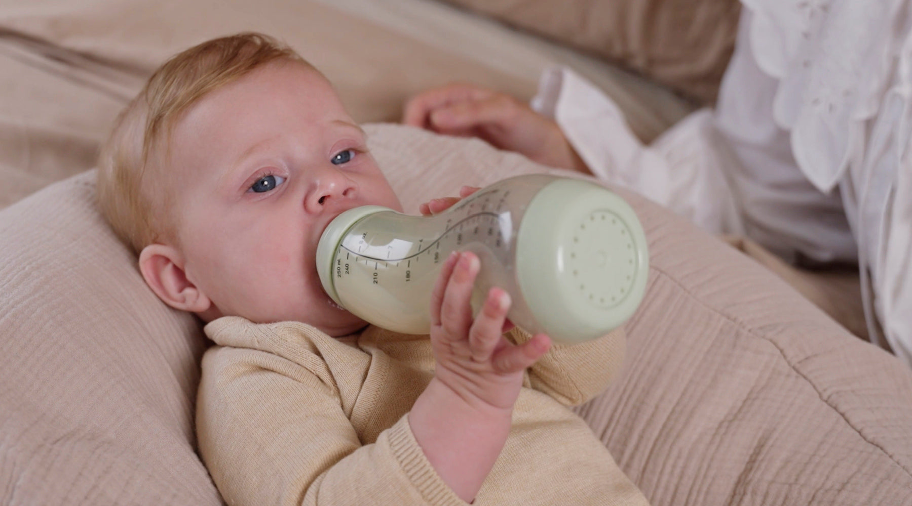 Kindje drinkt uit Difrax S-fles in pastel groene kleur