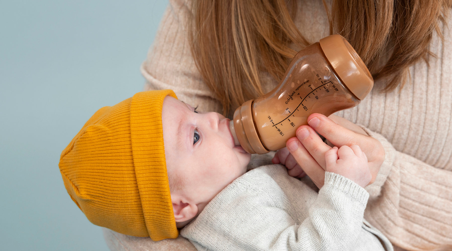 “Een moeder voedt haar kleine kind met een Difrax-fles melk.
