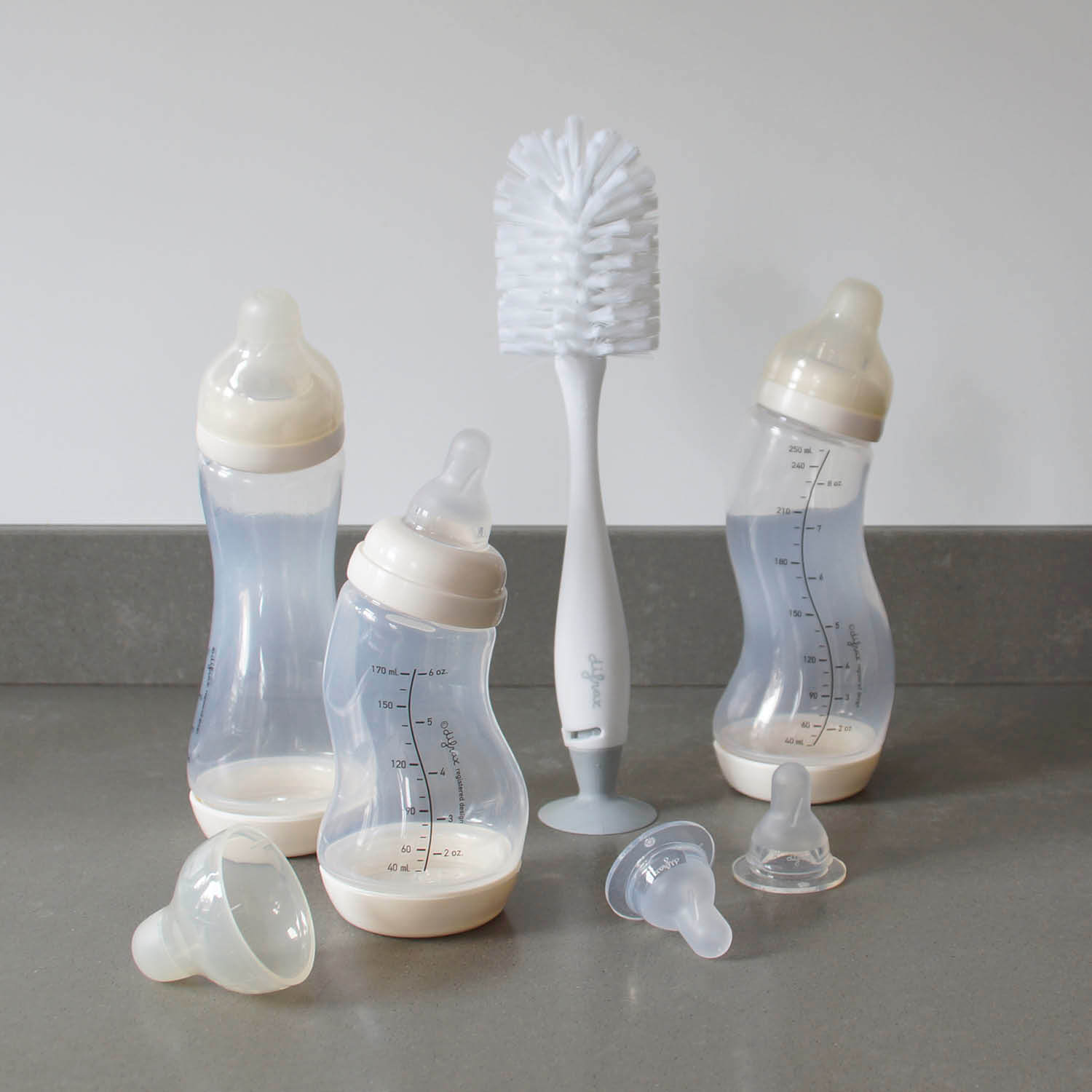 Difrax babyflessenset met drie S-flesjes, twee Natural spenen en flessenborstel met speenborsteltje op grijze ondergrond