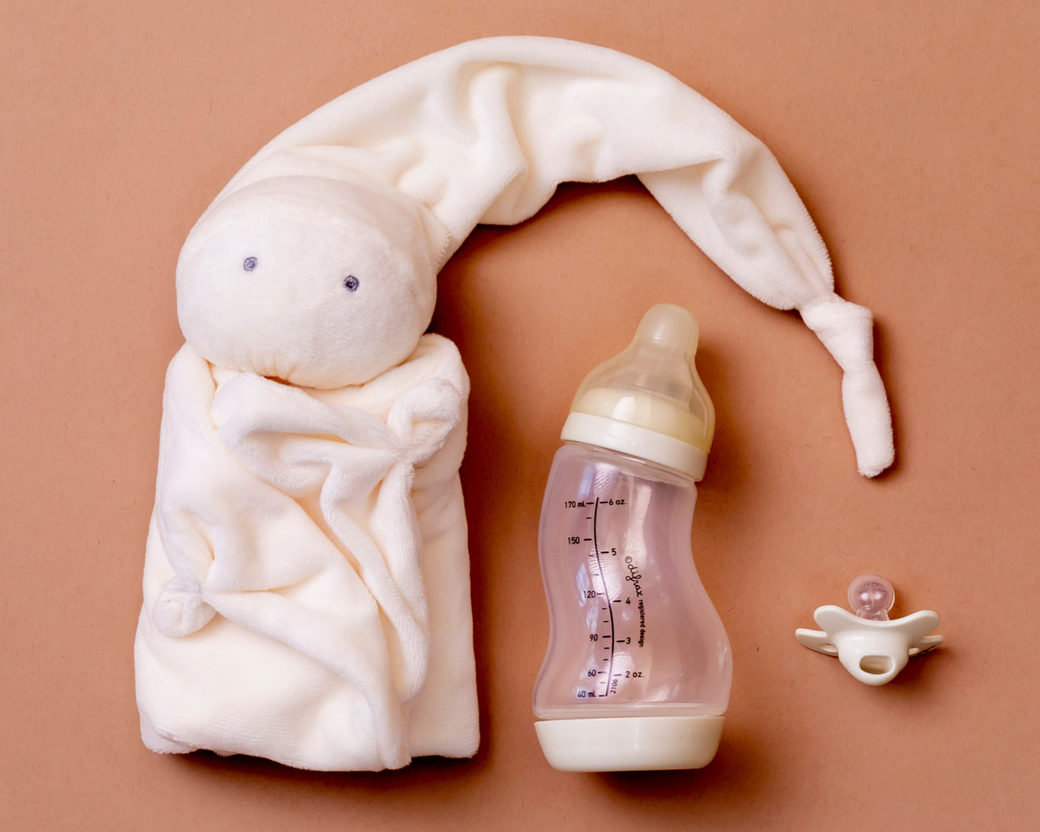Knuffeldoek samen met een baby fles en fopspeen