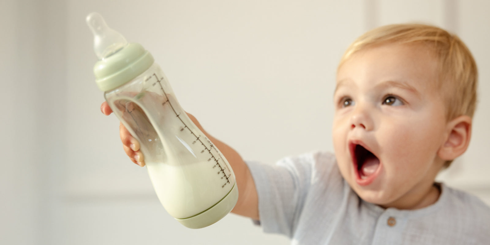 kindje houdt zelf de handgreepfles als ze melk drinkt