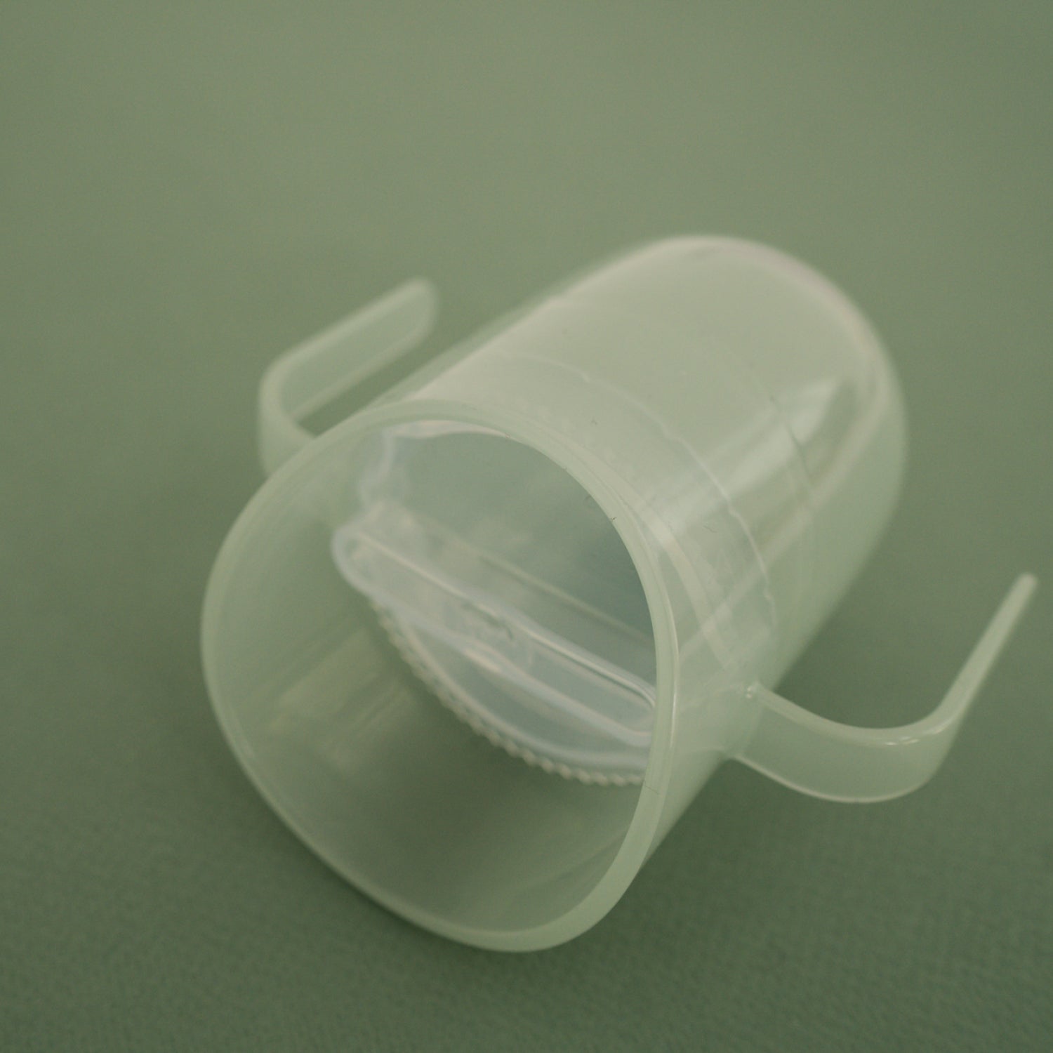 Difrax LOVI Genius oefenbeker in pistachio kleur op een tafel – stijlvol en functioneel babyproduct.