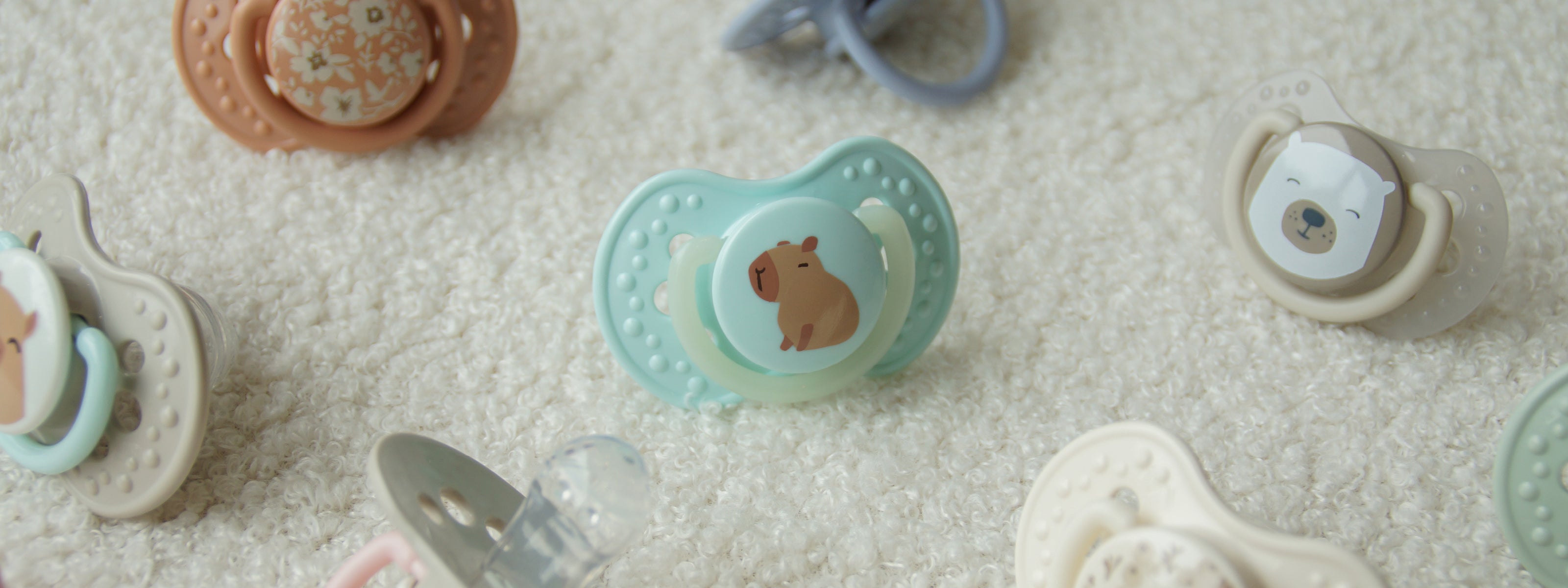 Verschillende speentjes van Difrax LOVI op een kleedje