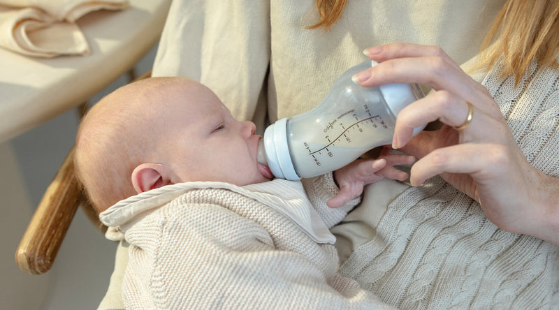 Baby drinkt uit Difrax anti-colic S-fles in armen van moeder
