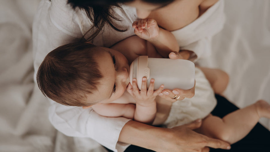 Bébé qui boit au biberon, nourri en toute sécurité et confortablement.