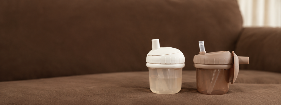 LOVI drinkbekers met rietje in ivoor en taupe op een bruine achtergrond.
