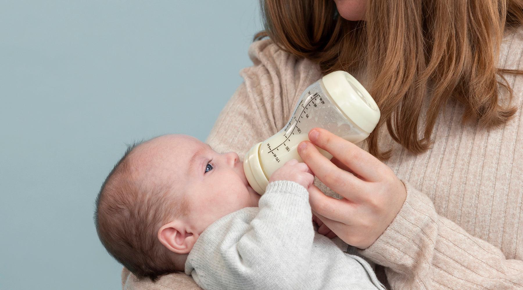 Moeder geeft baby voeding met Difrax S-fles