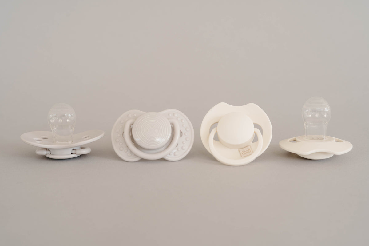 Sucettes Difrax LOVI en blanc avec différentes formes et détails.