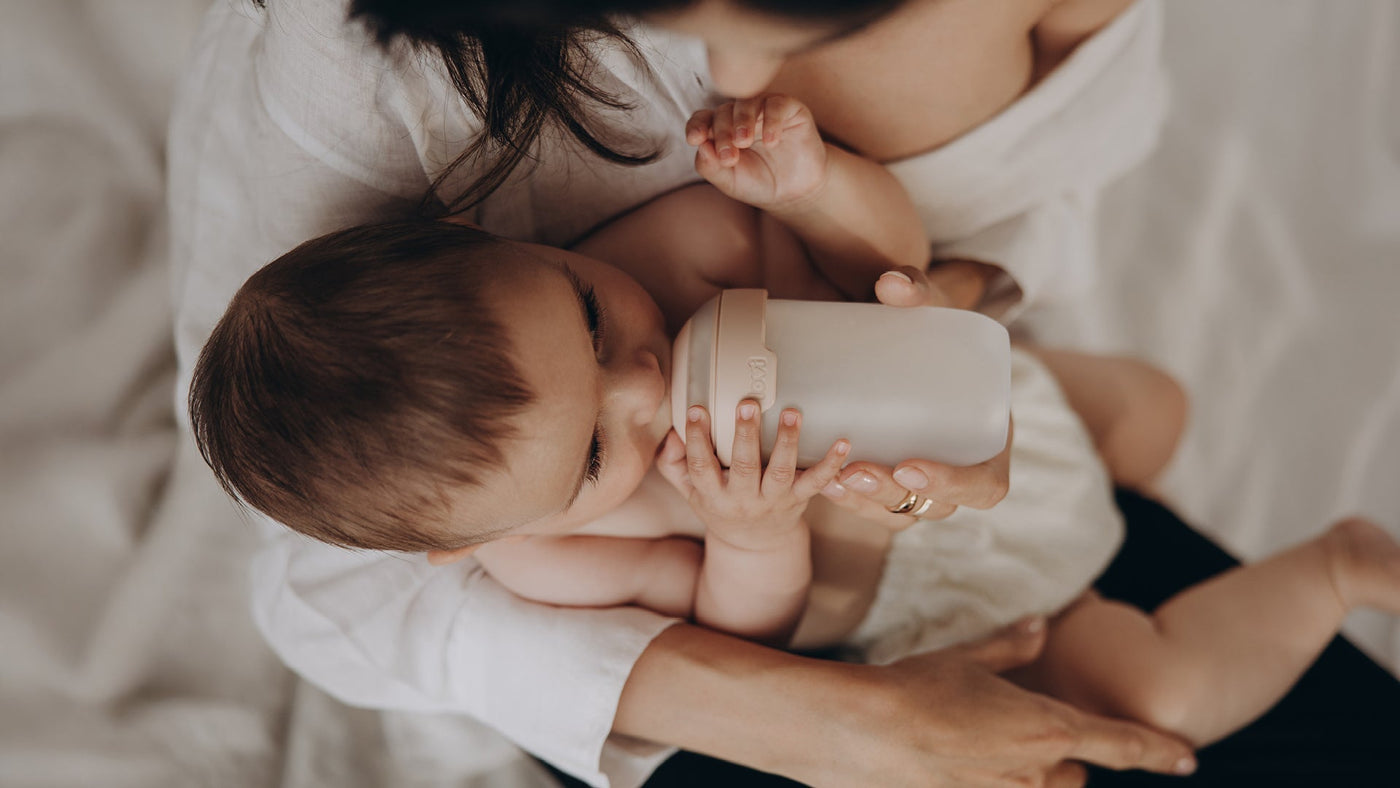 Bébé buvant au biberon Difrax dans les bras de sa maman