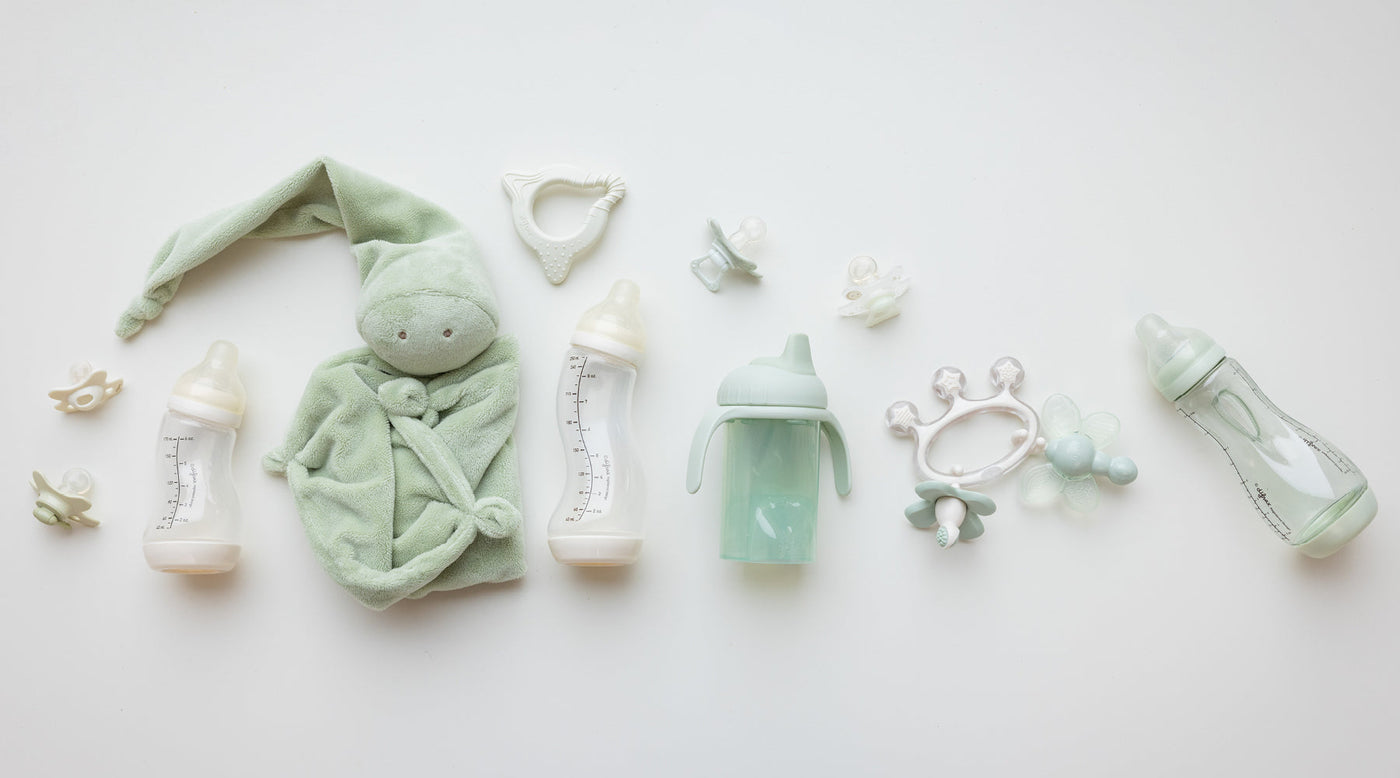 Difrax babyproducten flatlay met flessen, fopspenen en speelgoed