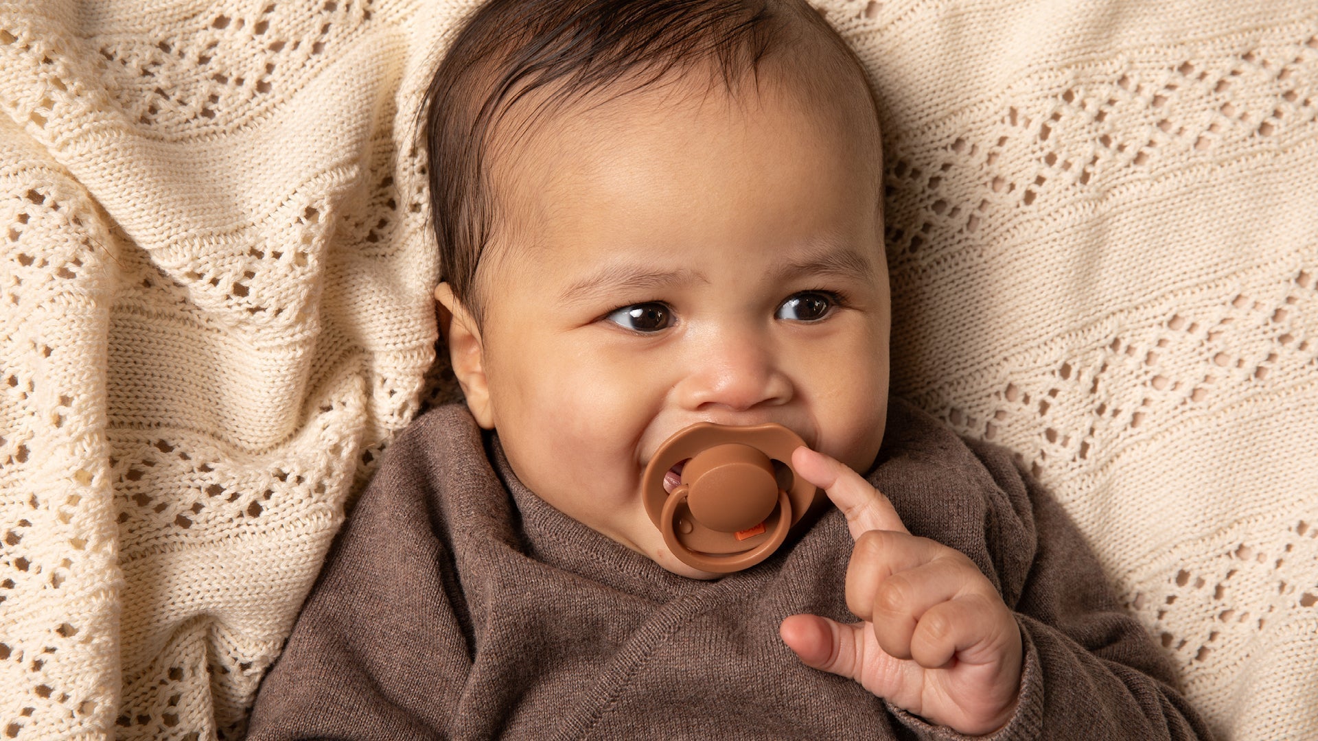 Bébé de 6 mois avec une sucette marron Difrax LOVI Prime