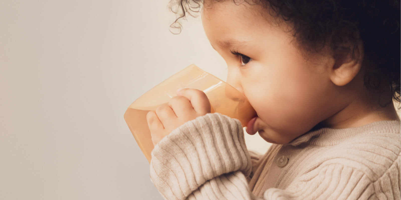 Bébé utilisant un gobelet et un bavoir Difrax pendant le repas