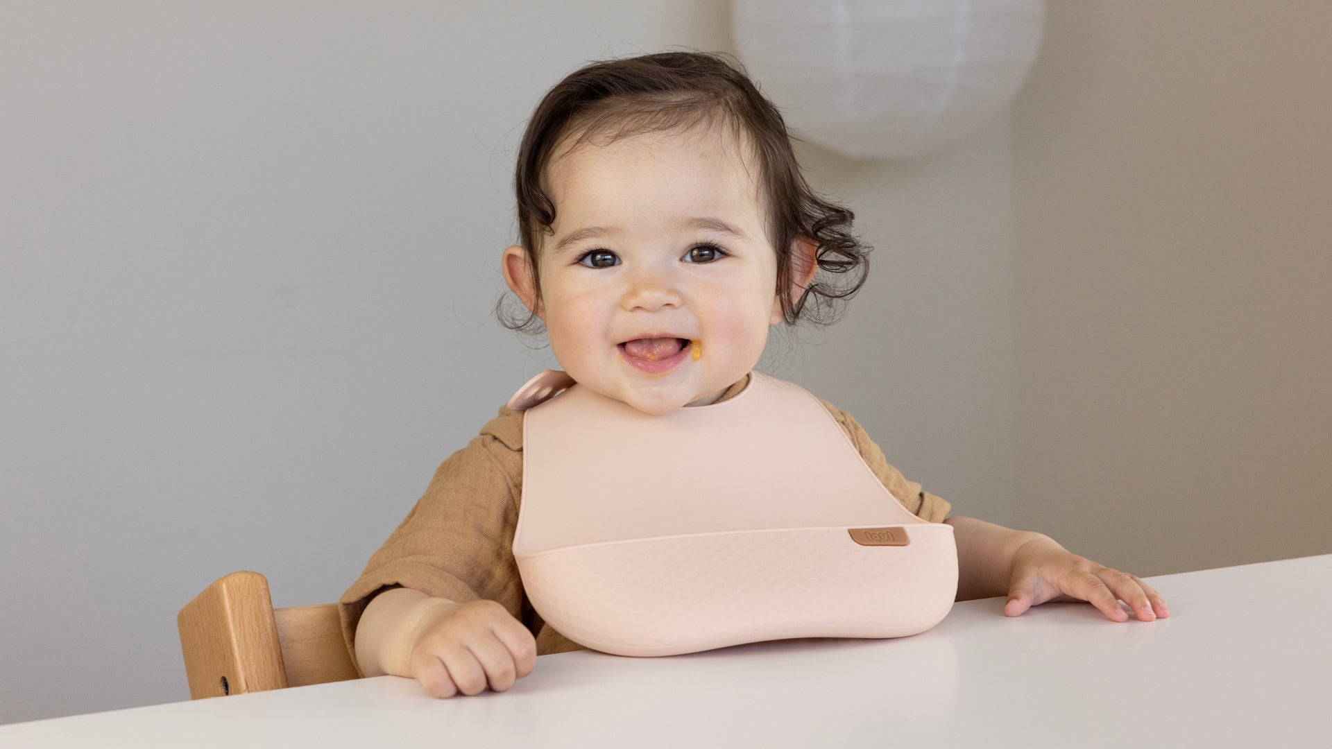 Bambin portant le bavoir en silicone Difrax LOVI à table