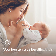 Moeder houdt een slapende baby vast tijdens het herstel na de bevalling thuis.