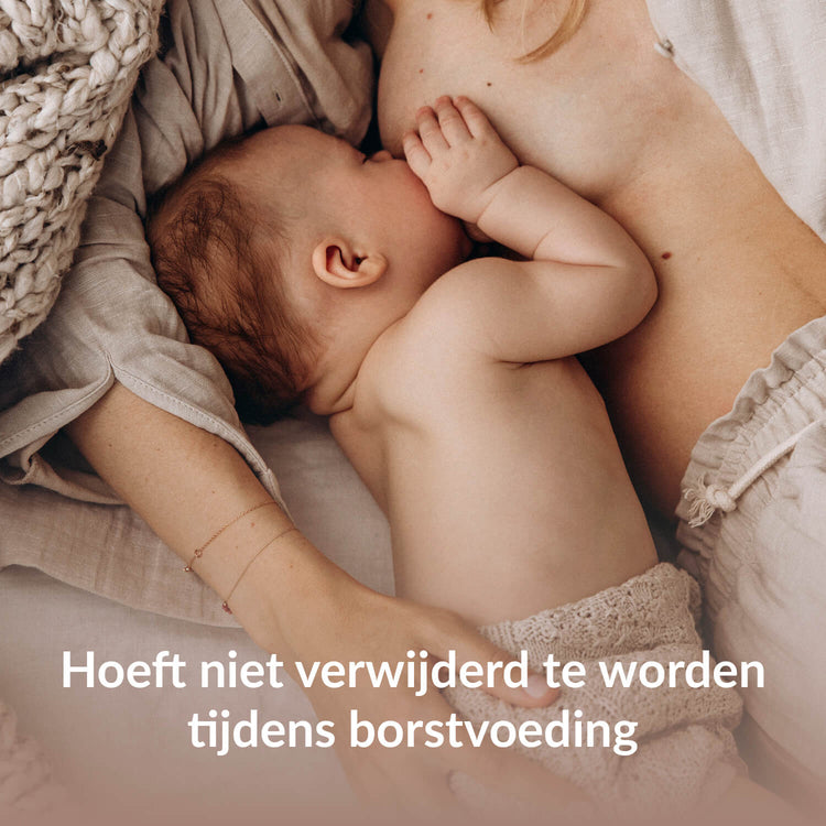 Moeder die haar baby borstvoeding geeft liggend, met de tekst 'Hoeft niet verwijderd te worden tijdens het geven van borstvoeding'.