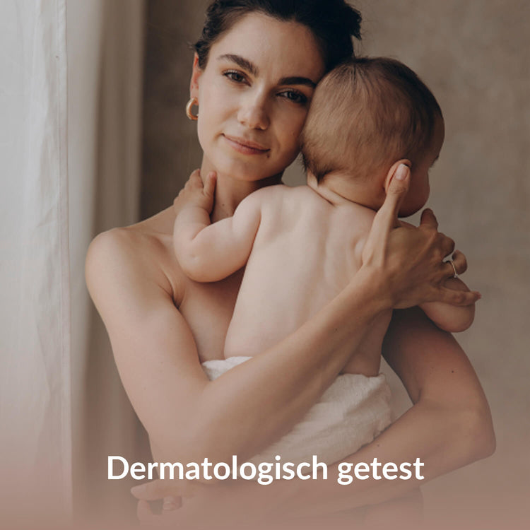 Moeder die haar baby vasthoudt, met de tekst "Dermatologisch getest" onderin beeld.