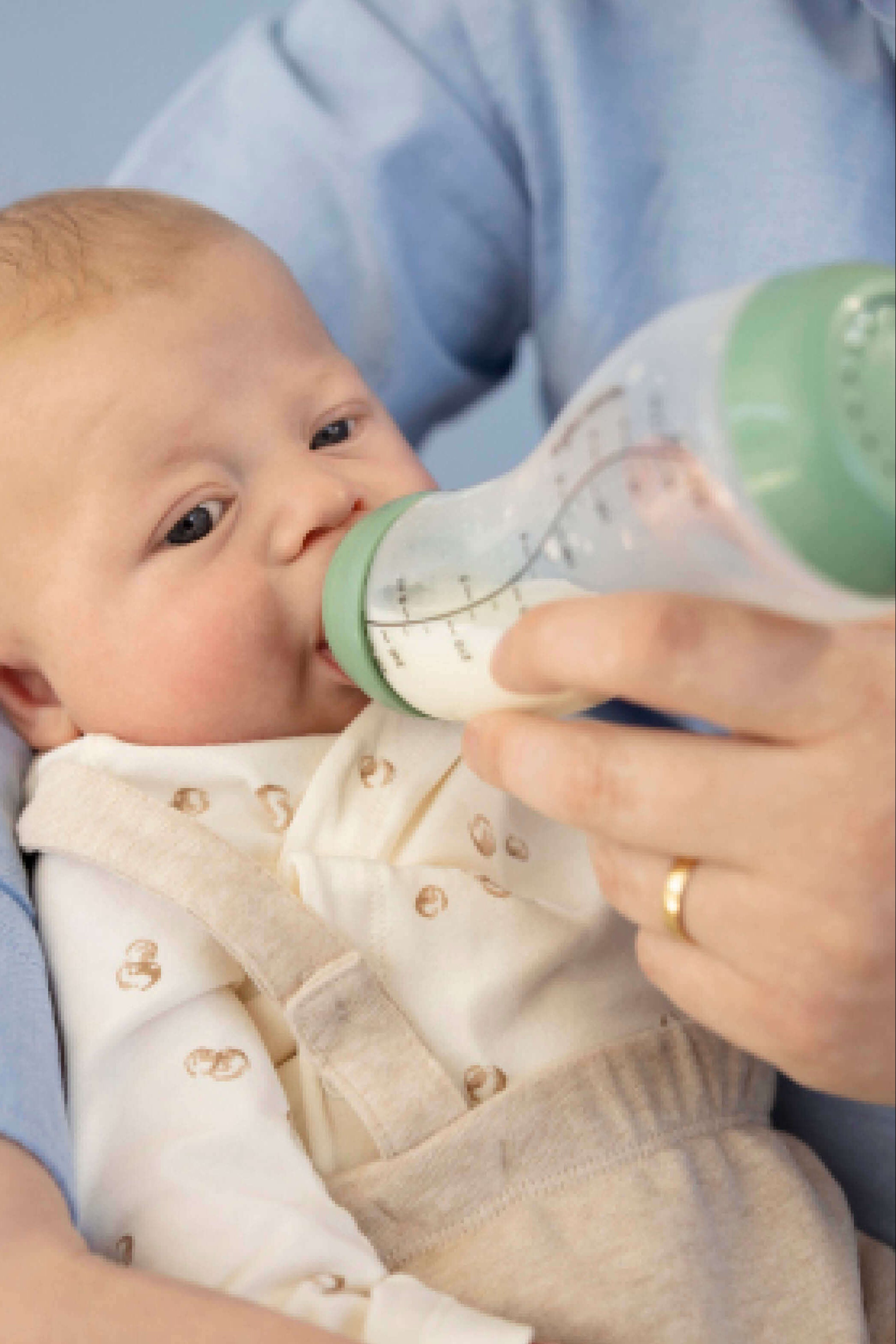 Pasgeboren baby wordt gevoed met Sage groene Difrax S-fles 250ml, intiem voedingsmoment in comfortabele positie