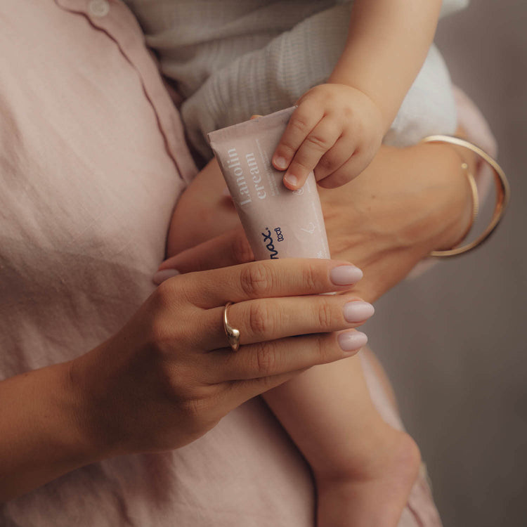 Moeder houdt een tube lanolinecrème vast voor verzorging tijdens de borstvoeding.