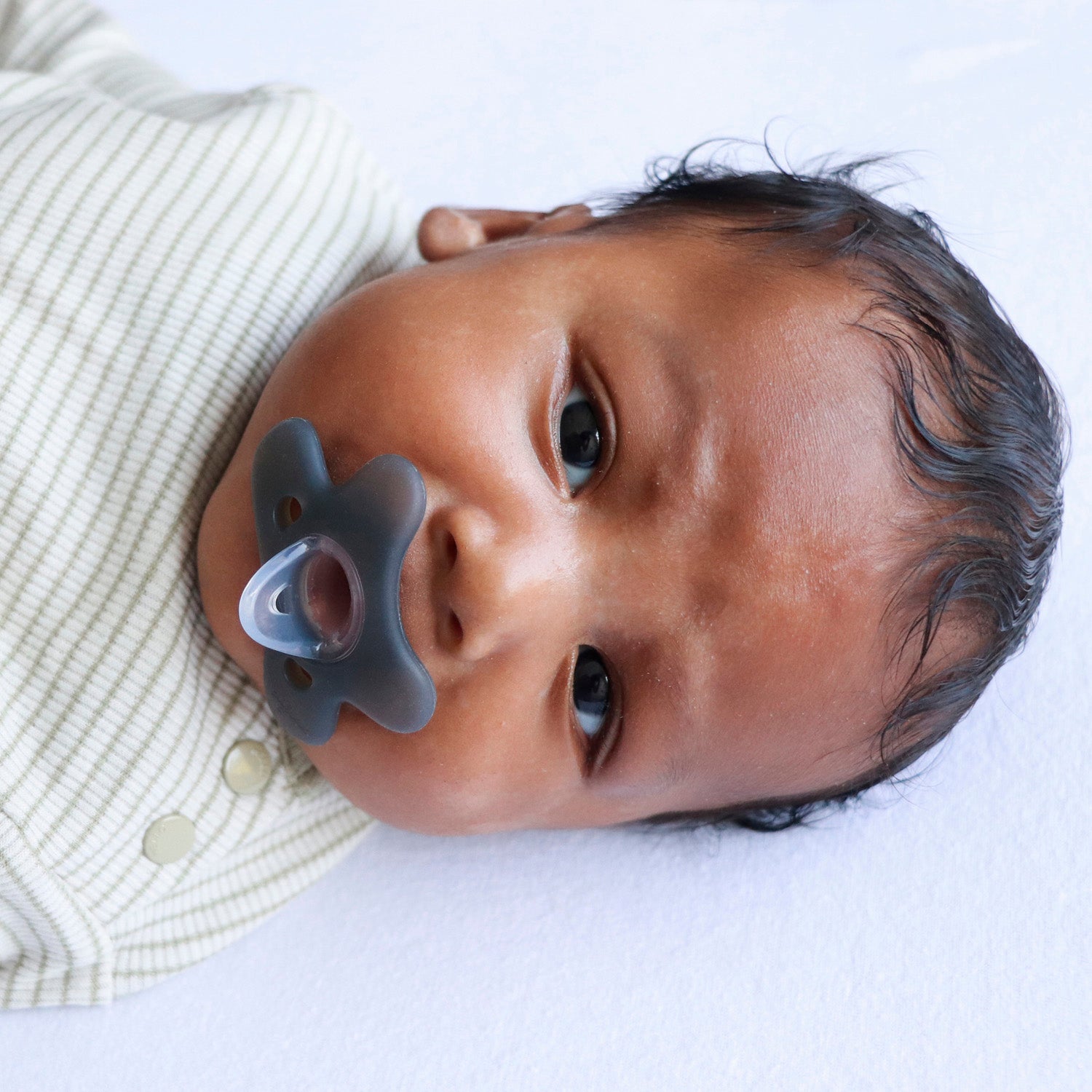 Baby met Difrax Natural siliconen fopspeen 0-6 maanden steel blue - ergonomisch vlinderschildje met ventilatieopeningen voorkomt huidirritati