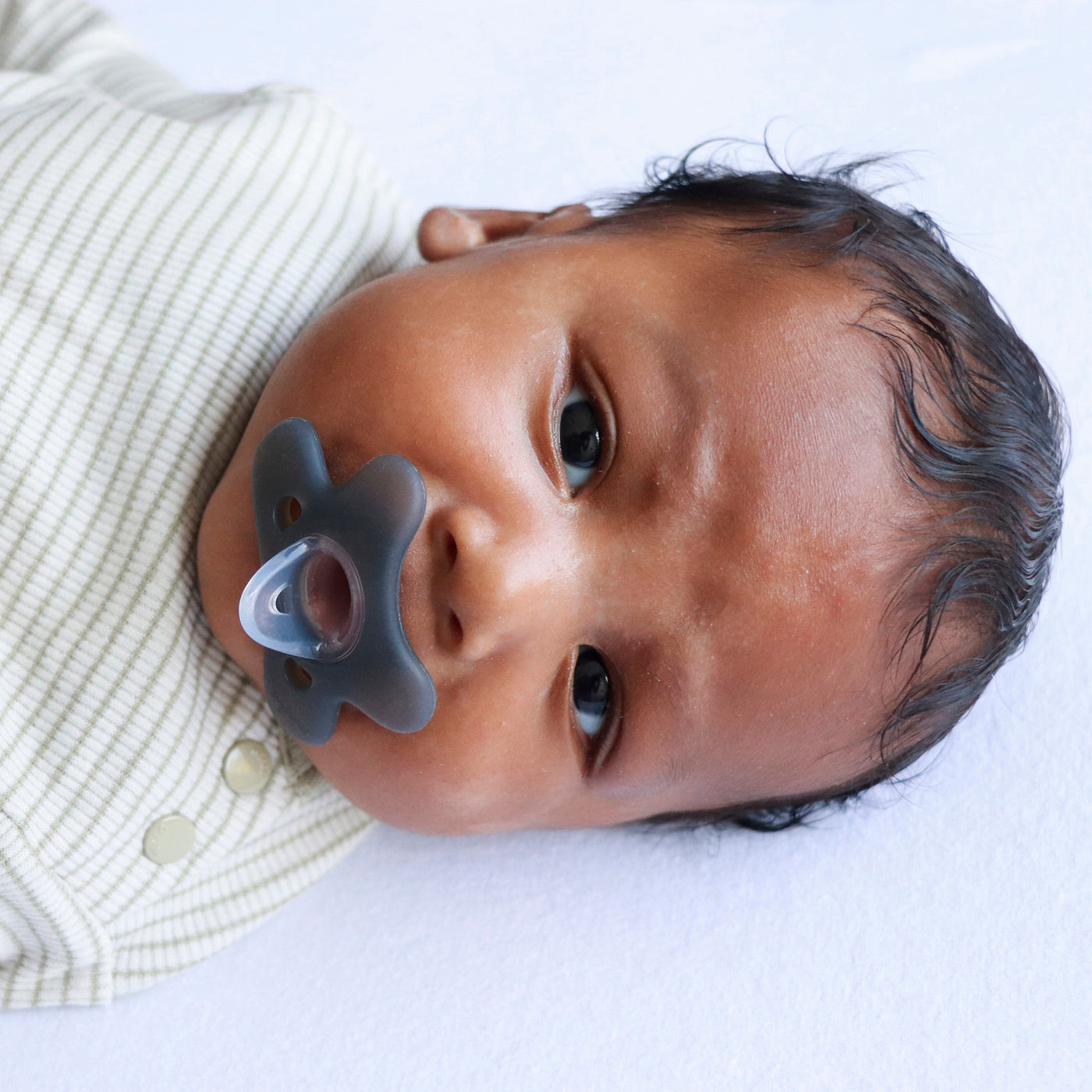Baby met Difrax Natural siliconen fopspeen 0-6 maanden steel blue - ergonomisch vlinderschildje met ventilatieopeningen voorkomt huidirritati